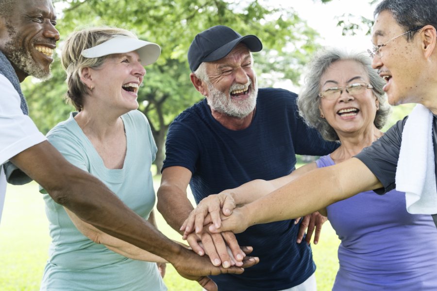 group of happy looking people with hands combined in a huddle