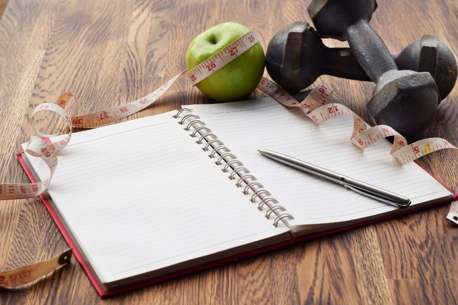 planning notebook with weights and an apple